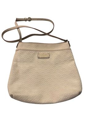 kate spade cream crossbody with embossed motif and gold plate